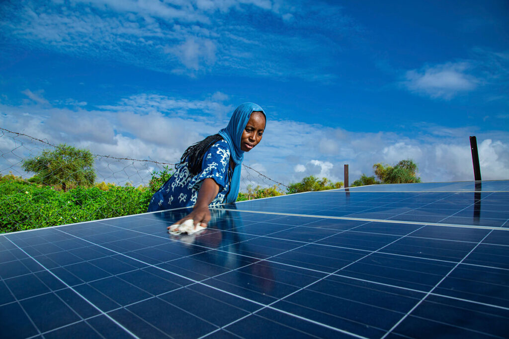 A a woman cleaning a solar energy panel in Mauritania